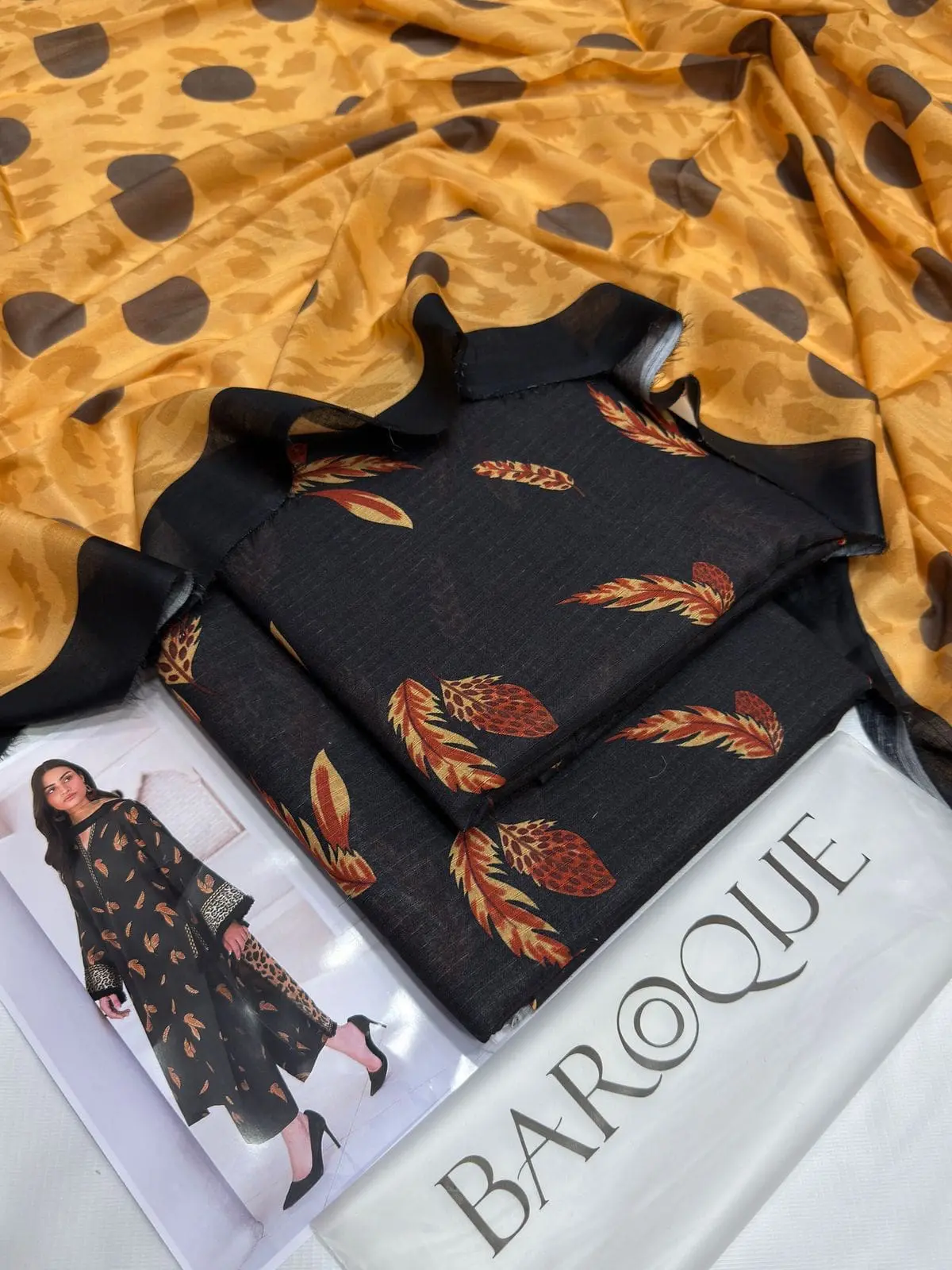 Unstitched black Baroque lawn suit with mustard dupatta and rust feather design