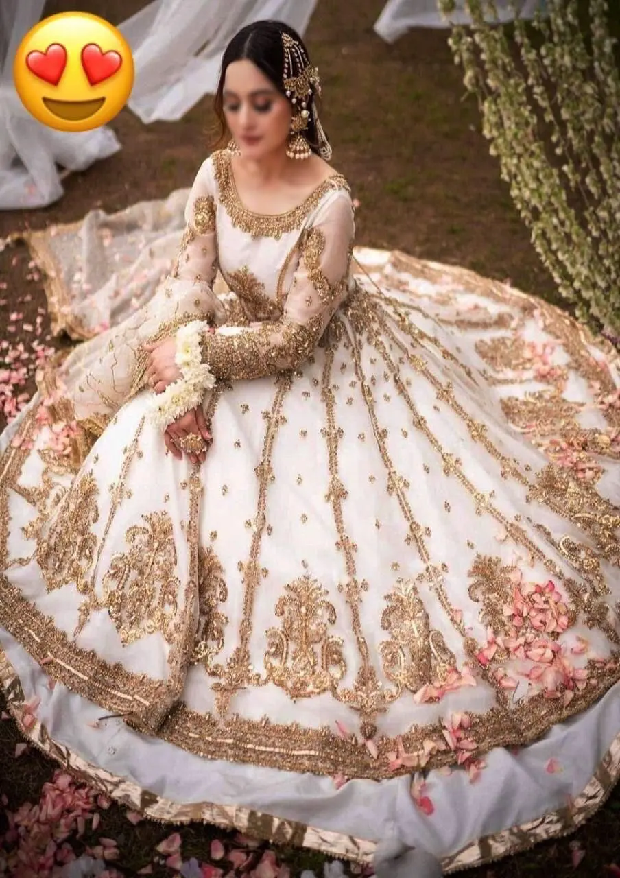 Bride wearing ivory maxi with heavy golden embroidery and floral details